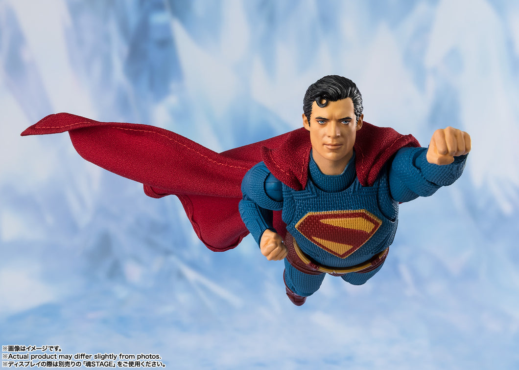 Superman action figure in flight against a snowy mountain background